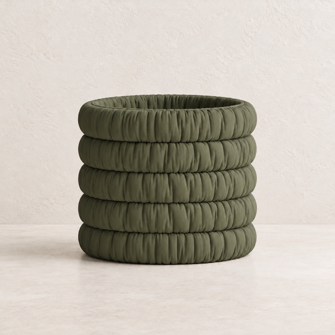 Mossmallow Planter in Dark Green (#656A4D), empty pot with warm plaster background and pale tabletop